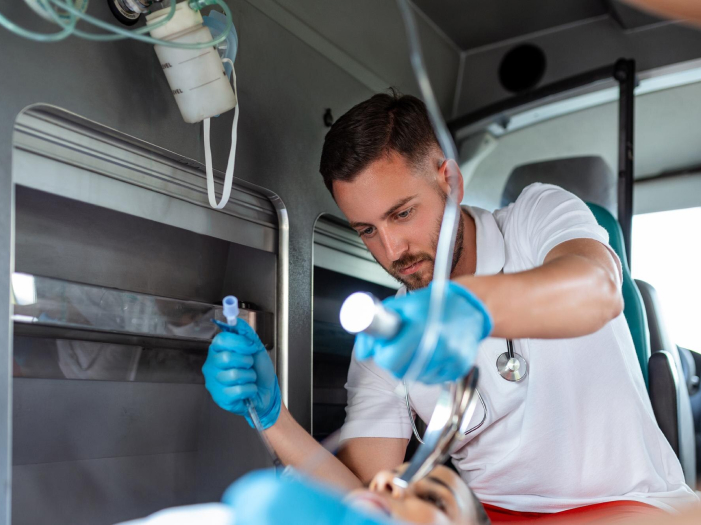 Paramédico aplicando tratamiento a un paciente dentro de una ambulancia
