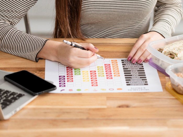 Trabajadora escribiendo en un calendario semanal con colores codificados